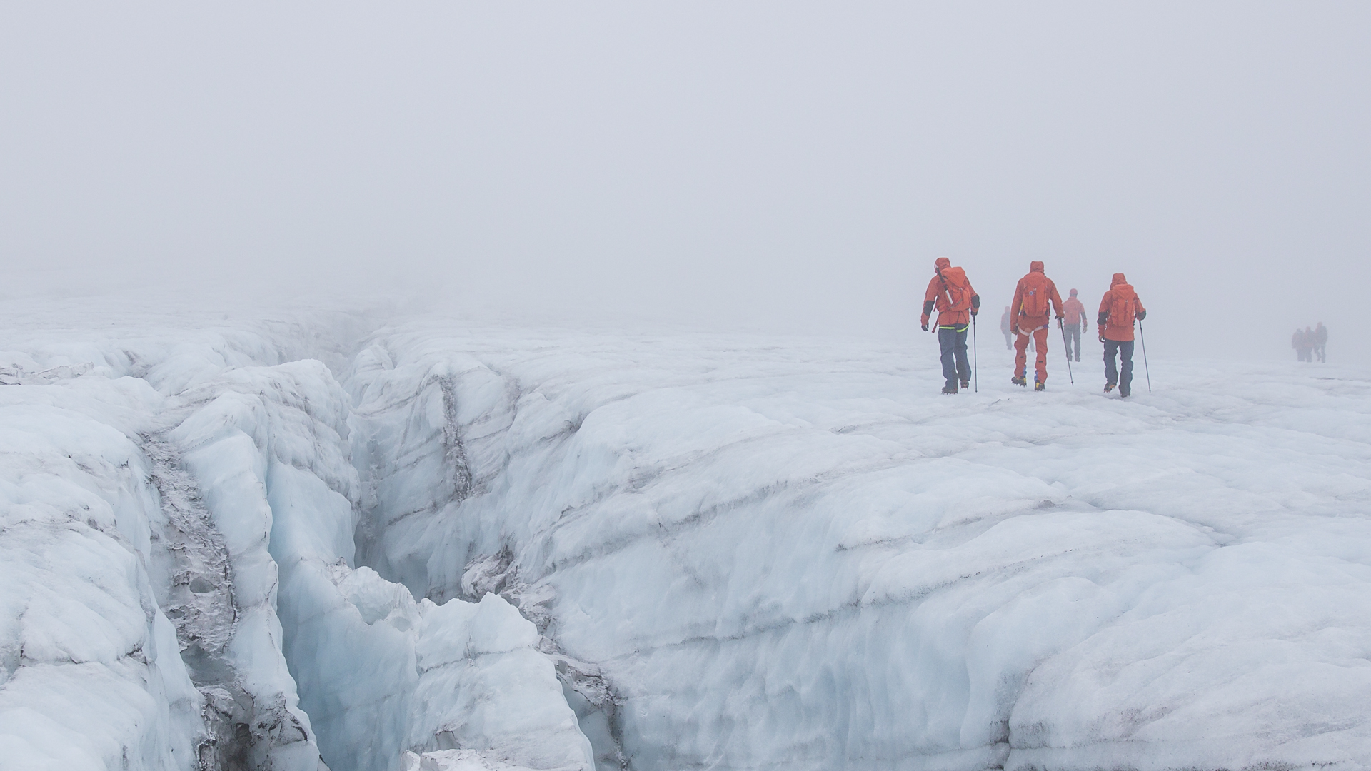 Vandrare vid isspricka i glaciär.