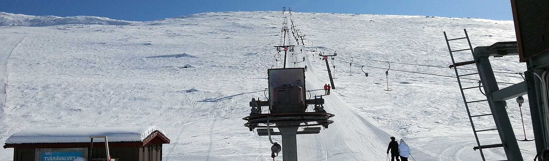 Skiers travelling in ski lift upwards a mountain slope