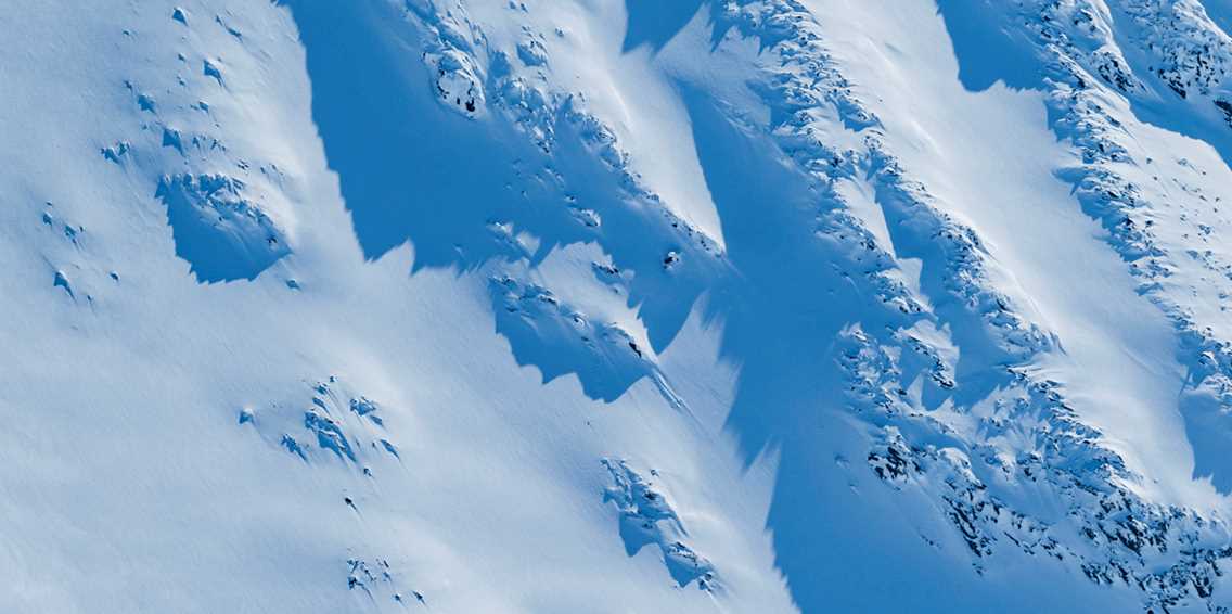 Offpist-skidåkare åker nedför orört snöfält
